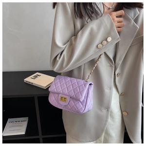 Detail of purple quilted leather crossbody bag with gold chain strap and twist lock