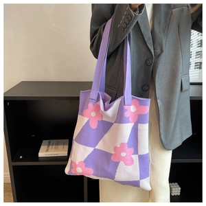 Detail of knitted purple checkerboard tote bag with pink floral patterns and thick texture
