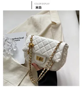 Detail of cream quilted crossbody bag with gold chain strap on a beige blazer