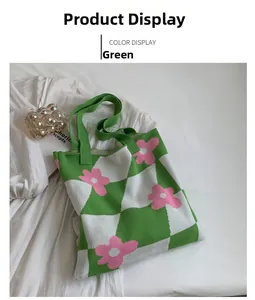 Close-up of green checkered knit tote bag with pink flower pattern on white fabric
