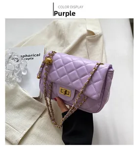 Detail of purple quilted chain bag with gold rectangular twist-lock on a blazer