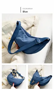Detalle del bolso bandolera de nailon azul en forma de medialuna con correa ajustable