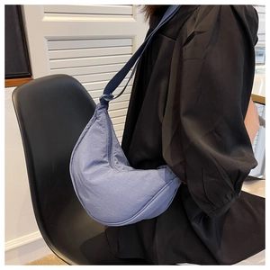Close-up of Morandi blue nylon crescent bag with adjustable knotted shoulder strap