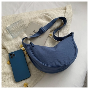 Detailed close-up of a navy nylon crescent crossbody bag with an adjustable wide strap