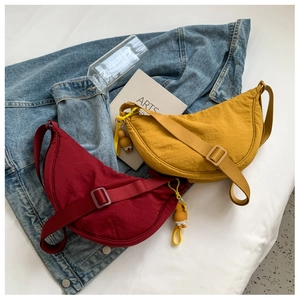 Detail of red and yellow nylon dumpling bags with cute duck charms in a lifestyle setting