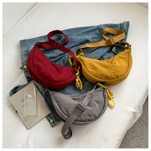 Three nylon crescent bags in red, yellow, and grey with cute duck charms and wide straps