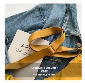 Close-up of bright yellow nylon bag showing adjustable shoulder strap with buckle
