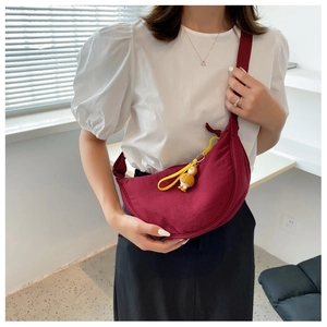 Dark red nylon crescent bag with adjustable strap and a cute yellow chick charm