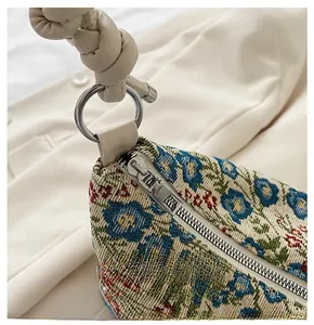 Detail of floral jacquard fabric with romantic pattern and smooth silver metal zipper