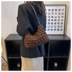 Detail of deep brown bubble texture fabric on a stylish ruched shoulder bag