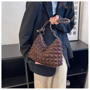 Detailed shot of coffee brown bubble textured shoulder bag with leather knotted straps