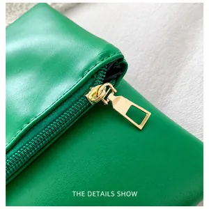 Detalle de cremallera dorada y textura de cuero verde en bolso sobre de estilo minimalista