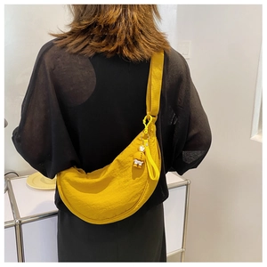 Detail of yellow nylon crescent crossbody bag with cute duck charm and adjustable strap