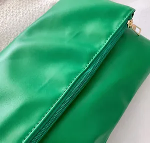 Primer plano de costuras de precisión y acabado en cuero PU verde liso de alta calidad