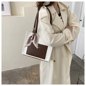 Detail of grid embossed tote bag with elegant silk scarf wrap and Paris Bag logo