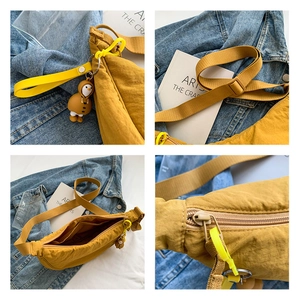 Close-up of ginger nylon crescent bag showing interior pockets and penguin charm