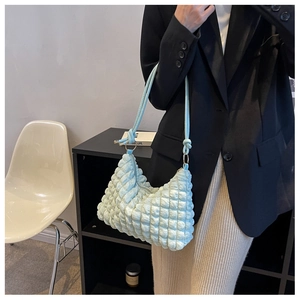 Detail of mint green ruched bubble fabric texture on a modern small shoulder bag