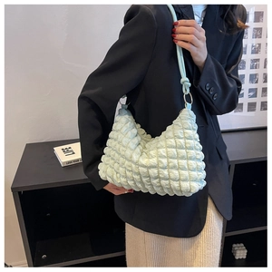 Close-up of light green popcorn textured shoulder bag with silver metallic rings