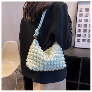 Side view of soft light blue bubble texture hobo bag worn by model in black suit