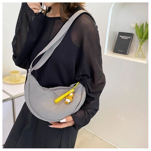 Gray nylon half-moon crossbody bag with adjustable strap and yellow cartoon duck charm