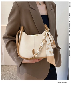Détail du sac crème avec bordure marron contrastée et foulard en soie décoratif chic