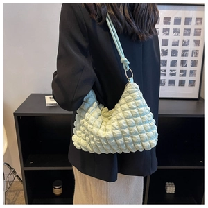 Close-up of mint green bubble texture fabric and gold metal ring on the shoulder bag