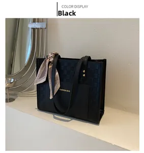 Detail of black checkered tote bag with fashion print and elegant silk scarf accessory