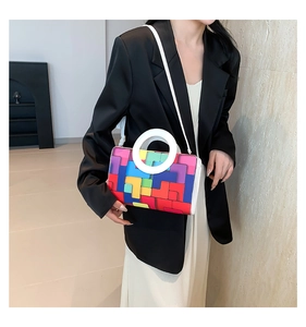 Détail du sac à main avec poignée ronde blanche et motif géométrique multicolore