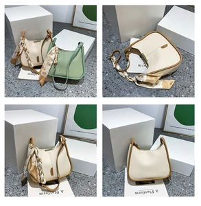 Détail du sac seau élégant crème et vert avec un foulard décoratif en soie sur l'anse