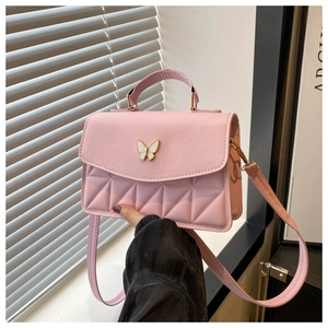 Close-up of pink crossbody bag featuring butterfly clasp and triangular quilted patterns