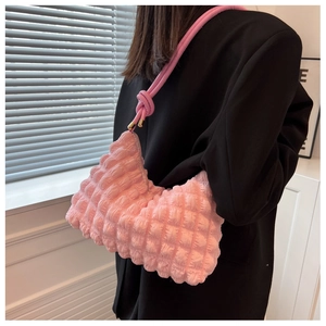 Close-up of pink pleated hobo bag with bubble texture and knotted shoulder strap