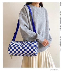 Details der blau-weißen Schachbrett-Zylindertasche mit breitem Nylon-Schultergurt
