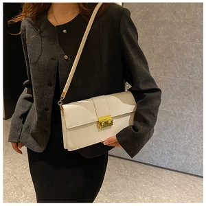 Close-up of cream textured leather shoulder bag featuring a vintage gold square lock
