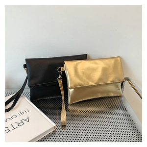Detalle de bolsos de sobre minimalistas en negro y dorado con correas de muñeca