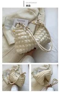 Detail of off-white quilted hobo bag with unique bubble texture and metal ring buckle