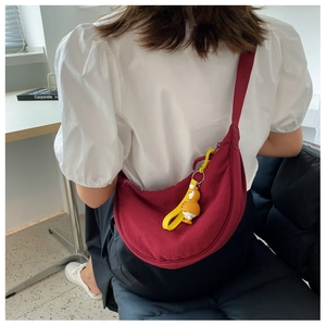 Deep red crescent nylon crossbody bag featuring a cute yellow duck pendant on strap