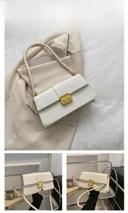 Detail of white crocodile pattern PU leather bag with golden metal buckle on beige suit
