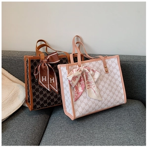 Close-up of canvas tote bags with monogram pattern and decorative bow ribbons