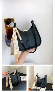 Détail du sac hobo noir en cuir grainé avec foulard en soie et finitions dorées