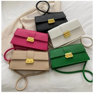 Close-up of five crocodile pattern handbags in various colors with gold metal buckles