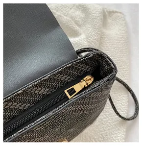Detailaufnahme des glatten goldfarbenen Reißverschlusses an der schwarzen Tweed-Tasche