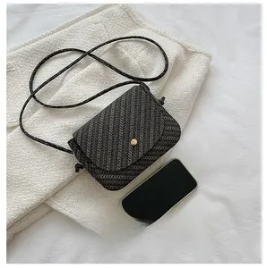 Detaillierter Größenvergleich der gewebten Mini-Satteltasche mit einem Smartphone