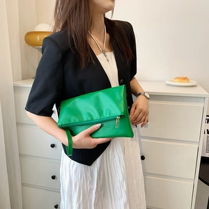 Cartera sobre verde brillante en cuero PU suave con correa de muñeca y cremallera dorada