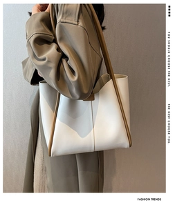 Detail of minimalist tote bag in off-white leather with deep brown contrast handles