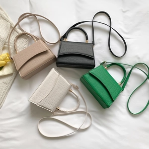 Mini crocodile pattern handbags in khaki, black, white, and green on elegant white fabric