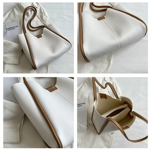Detail view of large white tote bag with brown contrast trim and inner zipper pouch