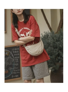 Model wearing a beige half-moon nylon crossbody bag with adjustable strap in casual style