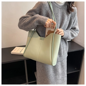 Close-up of a mint green oversized tote bag with stitching detail on high-quality leather
