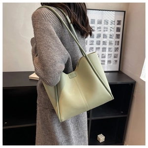 Side view of large mint green leather tote bag on model for daily lifestyle use