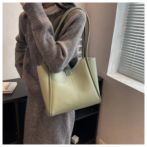 Detail of pistachio green PU leather tote bag with vertical stitching and slim shoulder straps
